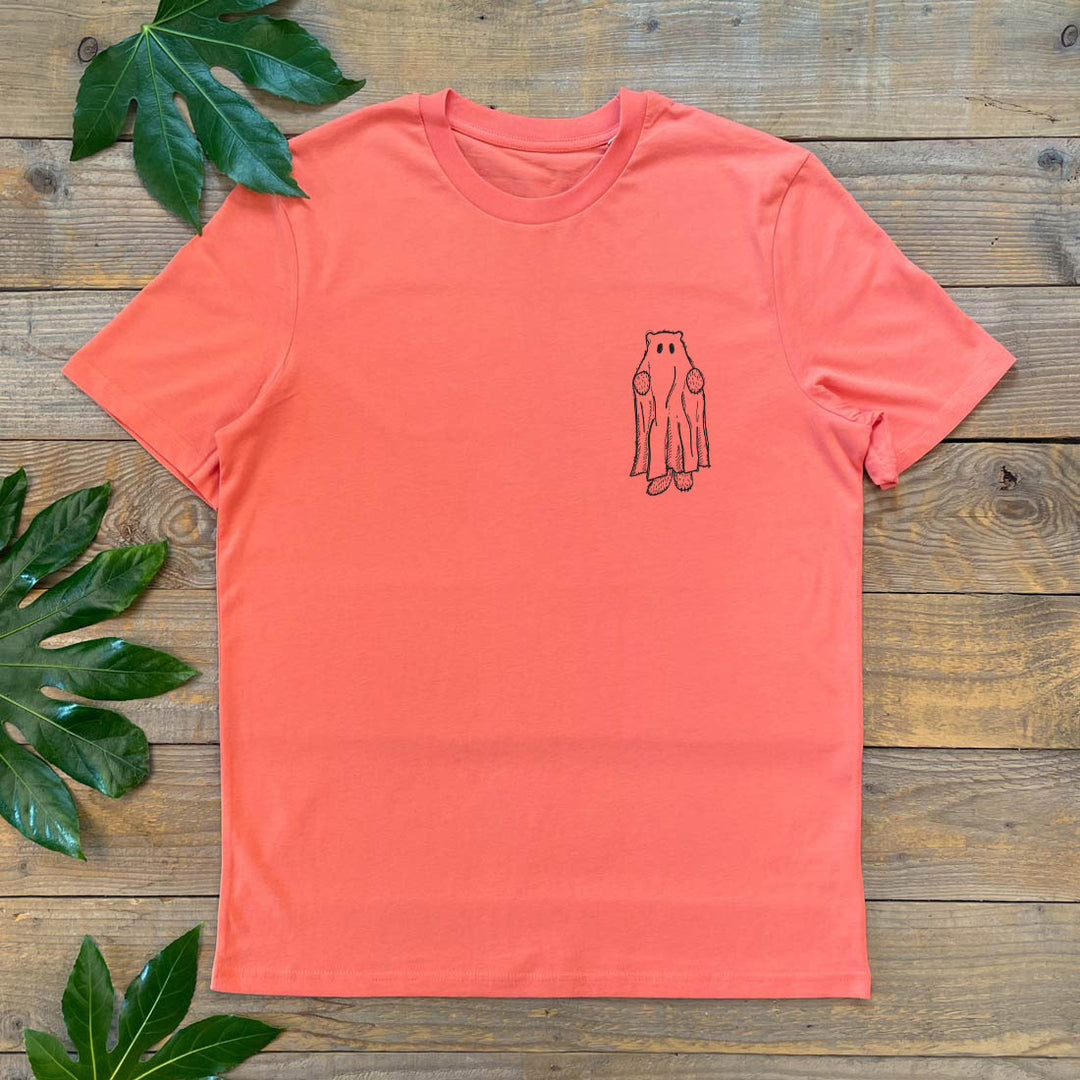 Coral t-shirt with a small graphic on a wooden surface with leaves.