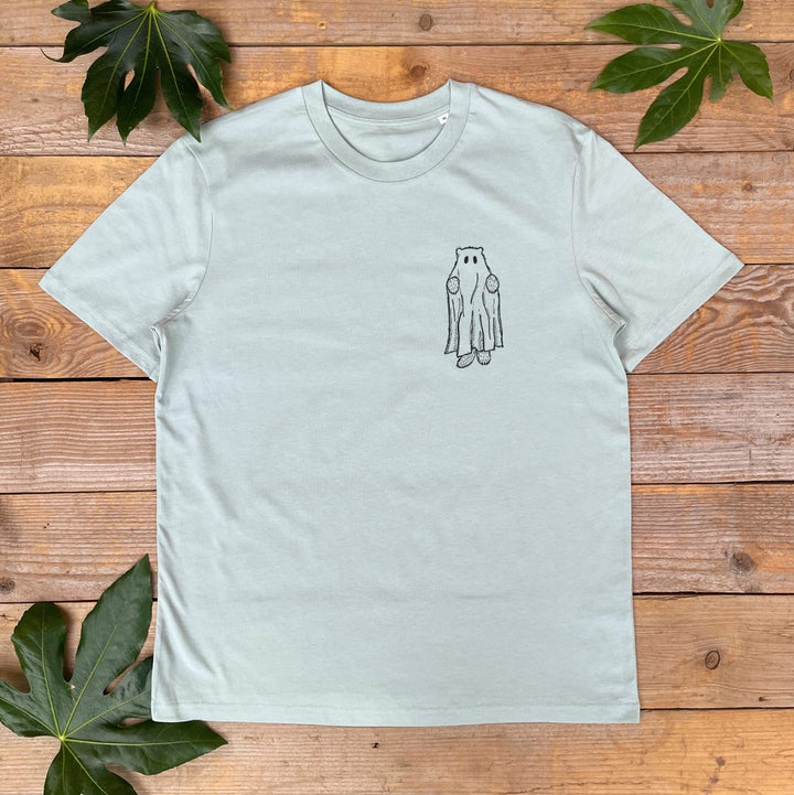 Light gray t-shirt with a small graphic on a wooden surface with leaves.