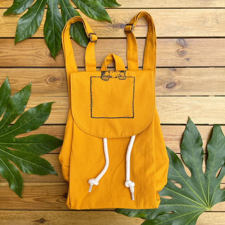 mustard backpack with peeking bear