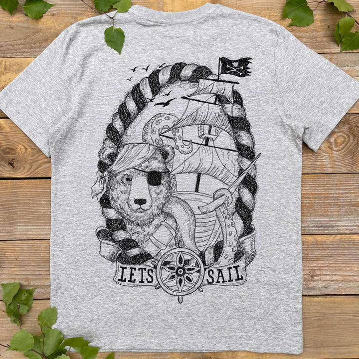 Gray t-shirt with a bear graphic and 'Let's Sail' text on a wooden surface.
