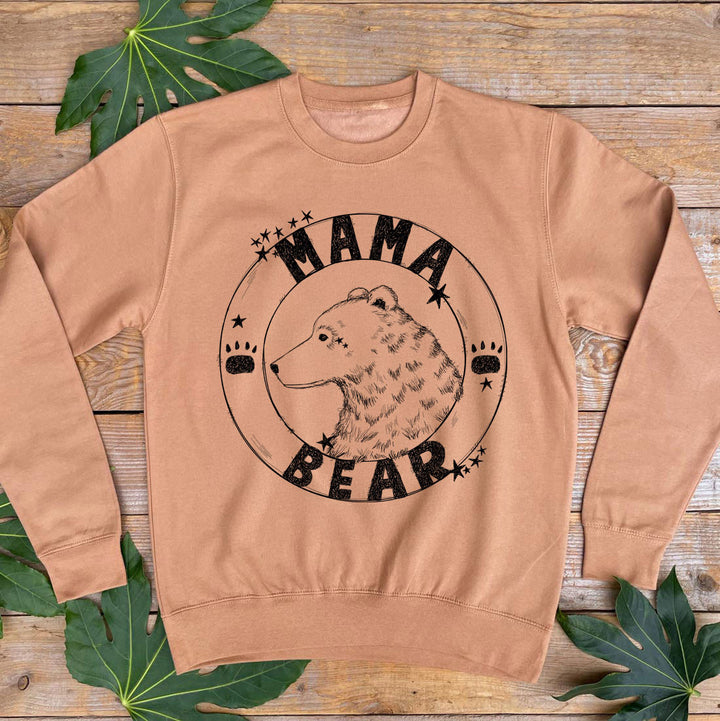 Coffee Brown sweatshirt with 'Mama Bear' graphic on a wooden surface with leaves.