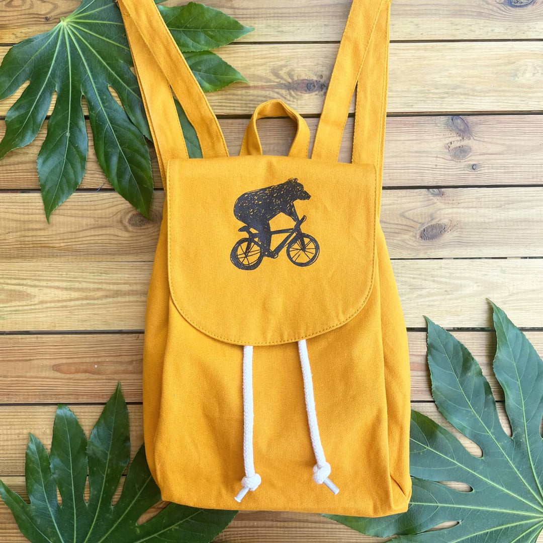 mustard backpack with bear and bike