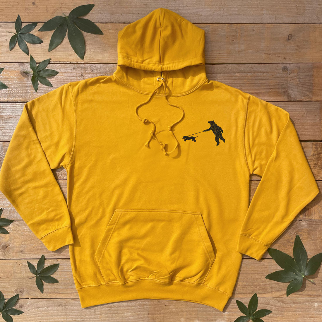 mustard hoodie with bear walking a dog