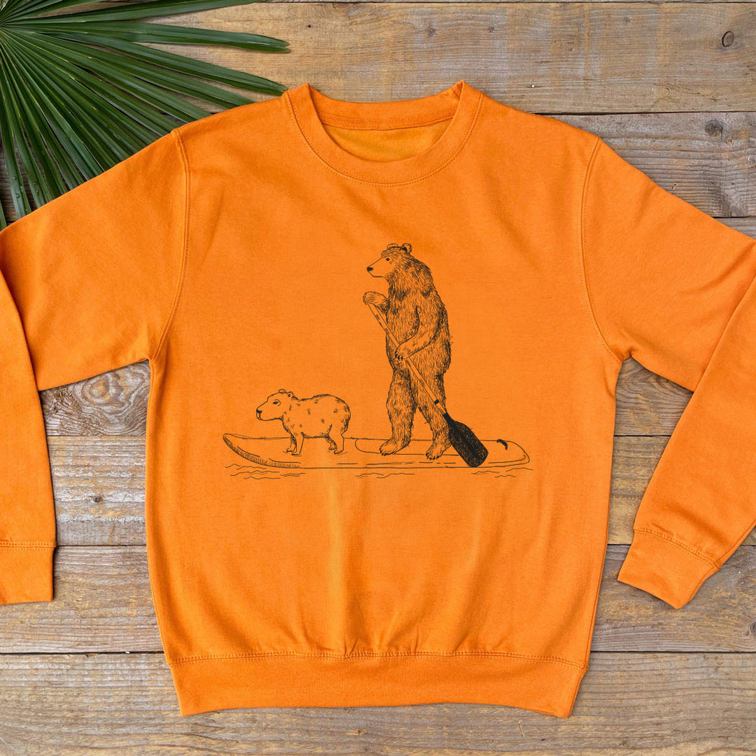 orange jumper with bear paddle boarding