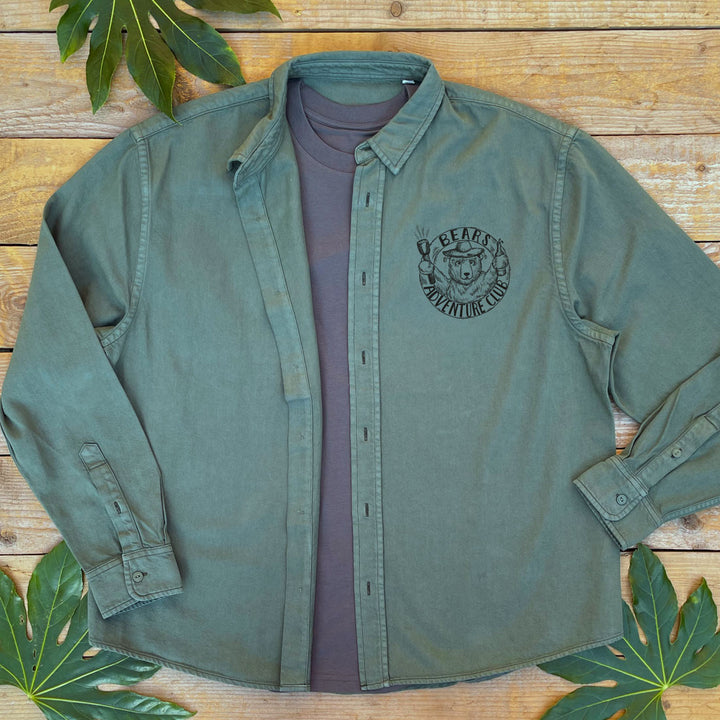olive green shirt open with a t-shirt underneath with a bears adventure club design on the pocket