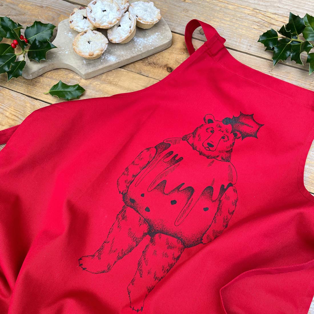 red apron with a bear dressed as a pudding on it