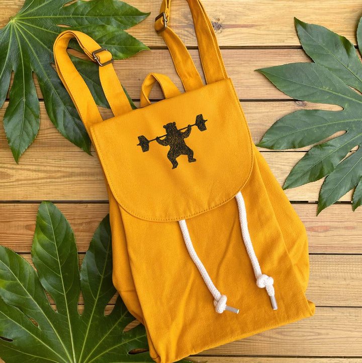 mustard backpack with bear weightlifting design